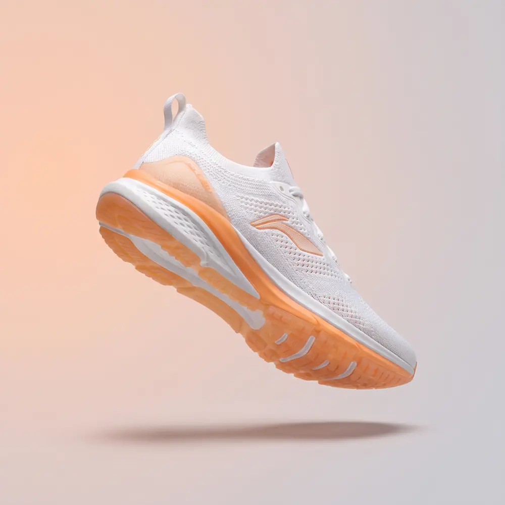 A running sneaker photographed on a soft grey gradient backdrop